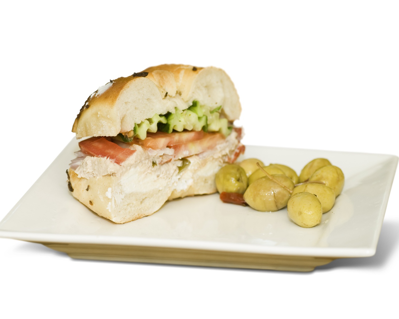 Половина гамбургера на тарелке с оливками