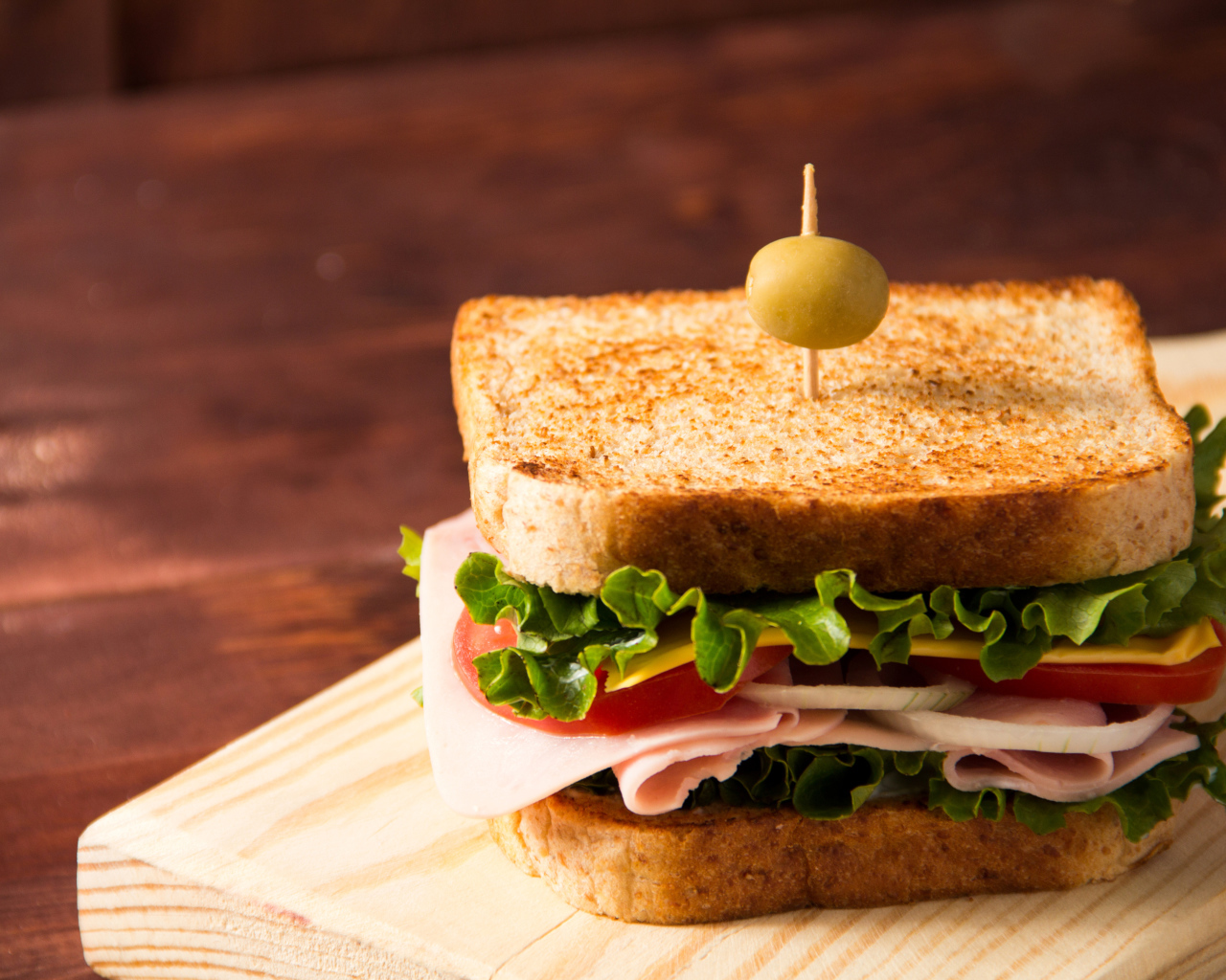 Гамбургер с ветчиной, помидорами, листьями салата и сыром