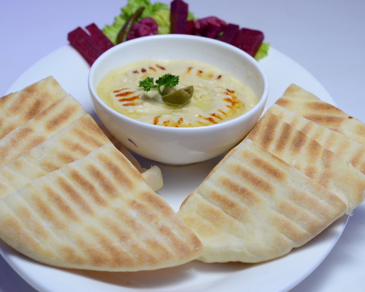 Хумус в белой тарелке с лавашом