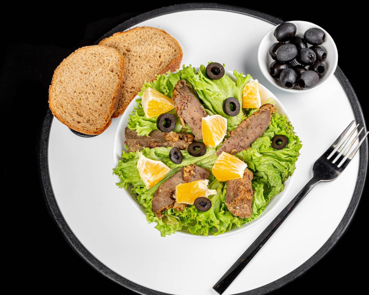 Листья салата с мясом на столе с хлебом