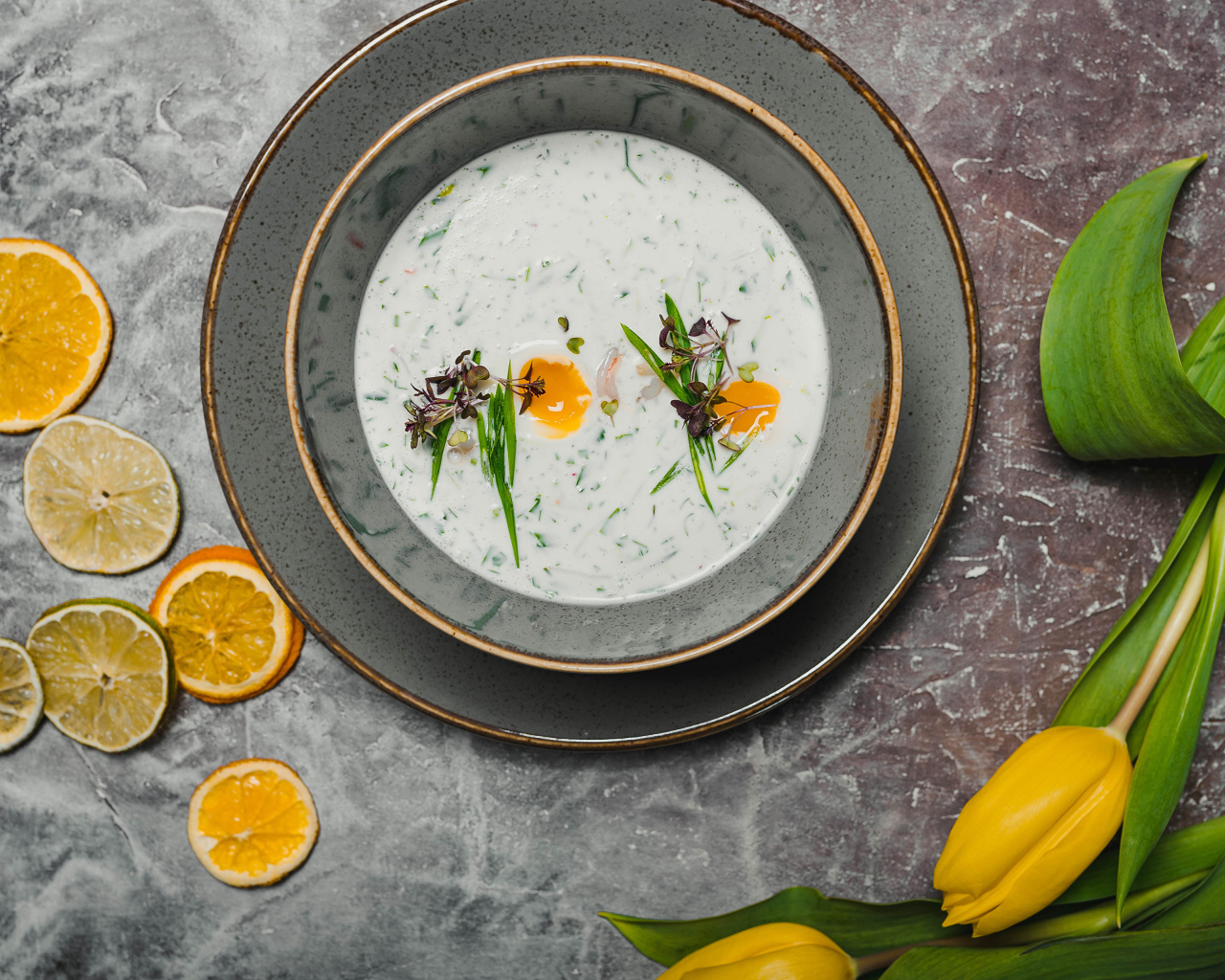 Окрошка на столе с лимонами и тюльпаном