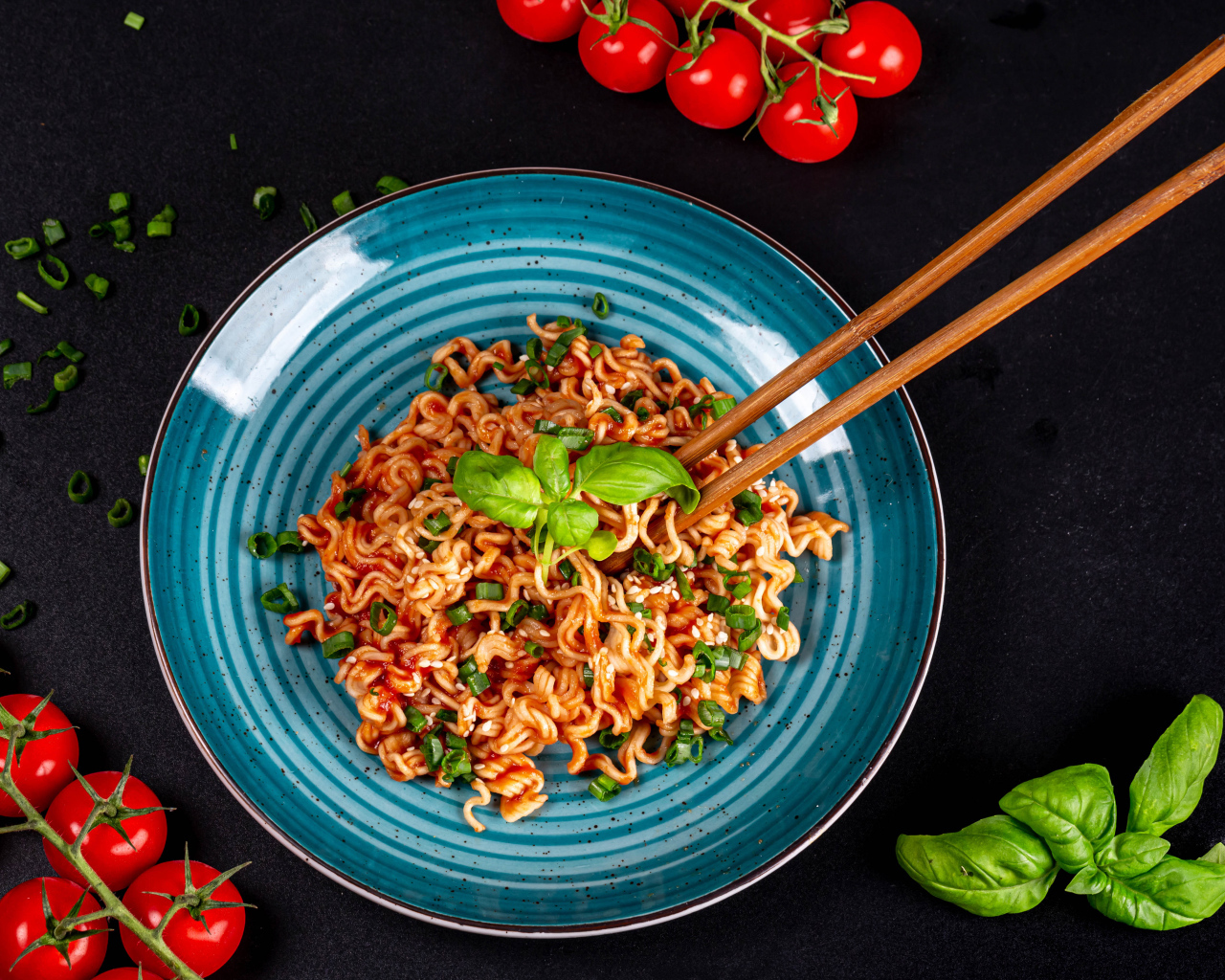 Макароны в соусе на столе с помидорами