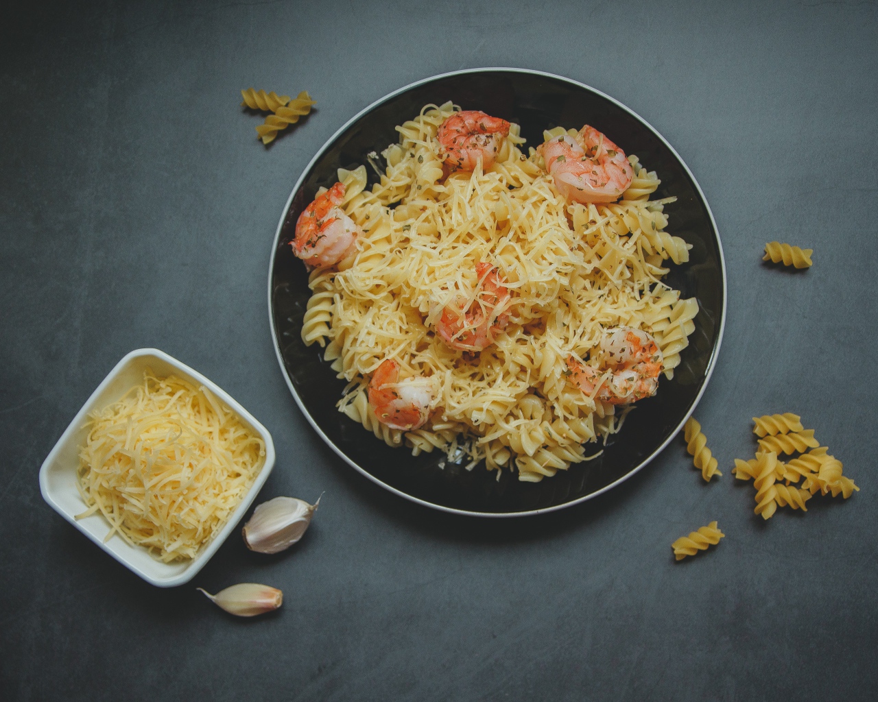 Макароны на тарелке с сыром и креветками