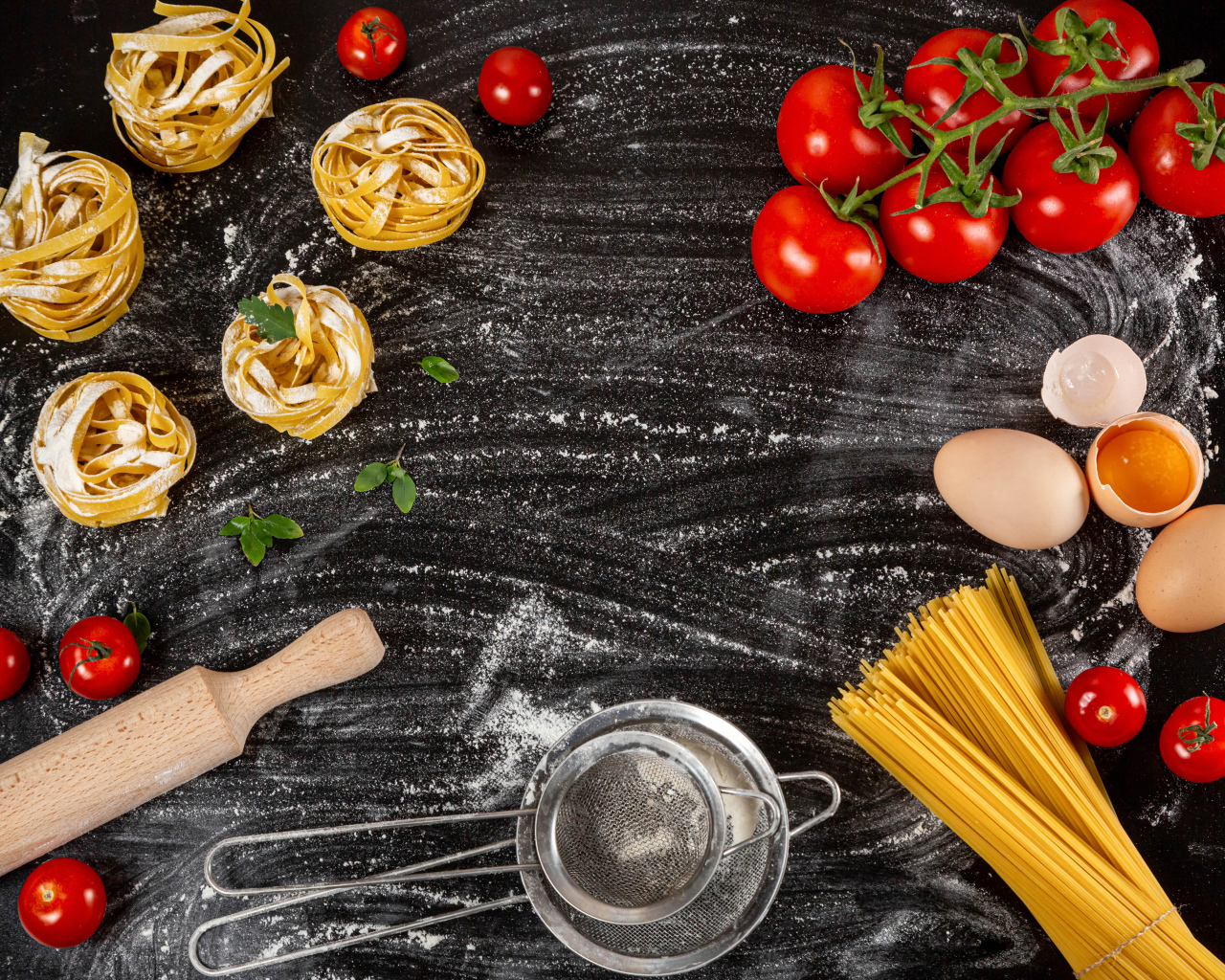 Паста с помидорами и яйцами на черном столе 