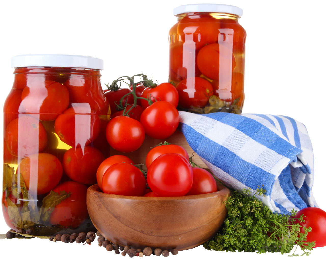 Маринованные помидоры в банках на столе со свежими