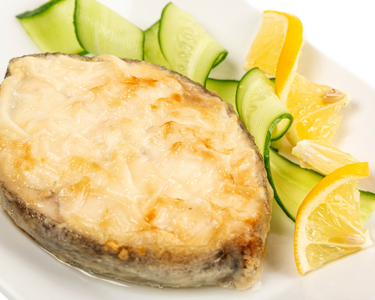 Картофель с сыром на тарелке с огурцами и лимоном 