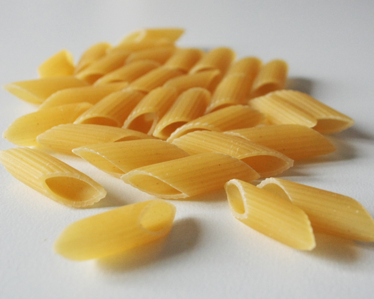 Сырые желтые макароны на сером фоне