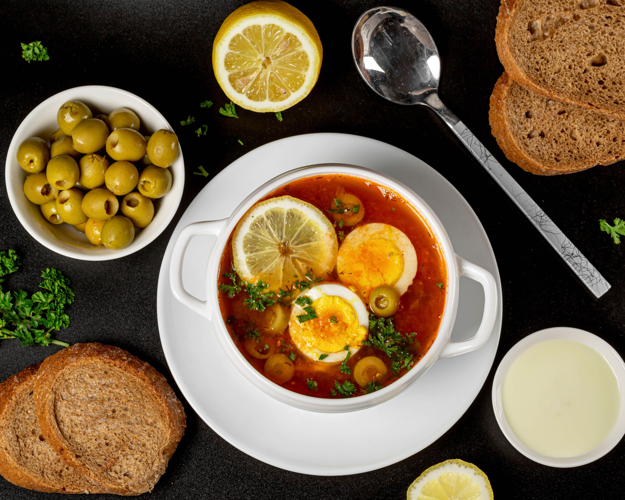 Солянка на столе  с хлебом и оливками 