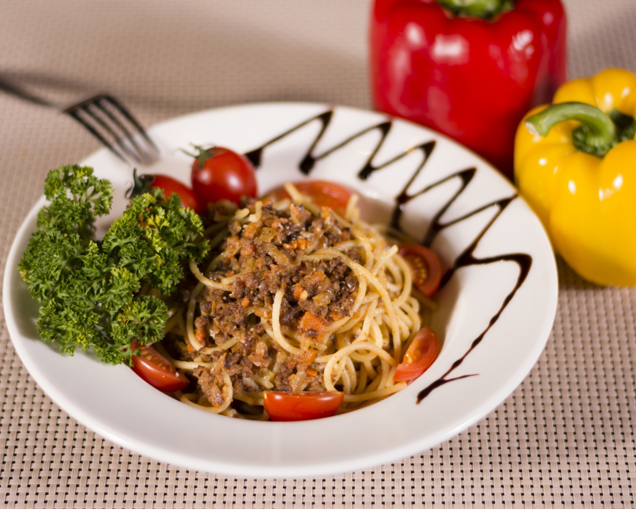 Спагетти с фаршем и помидорами в тарелке 