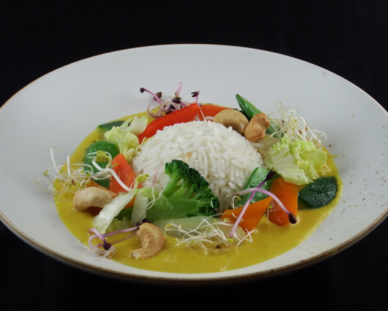 Вареный рис с овощами в большой белой тарелке