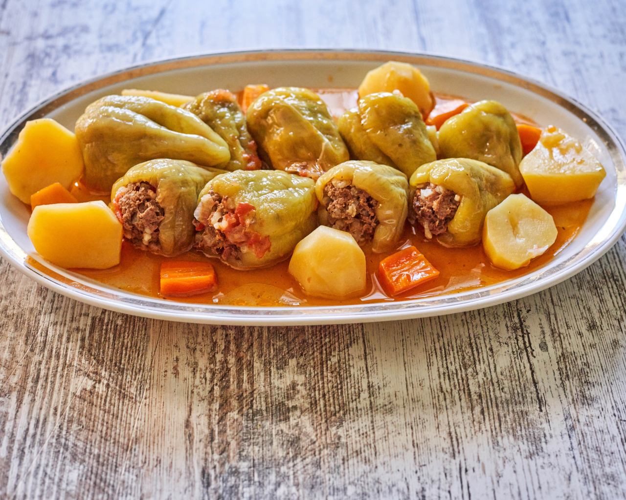 Фаршированный перец на тарелке с картофелем