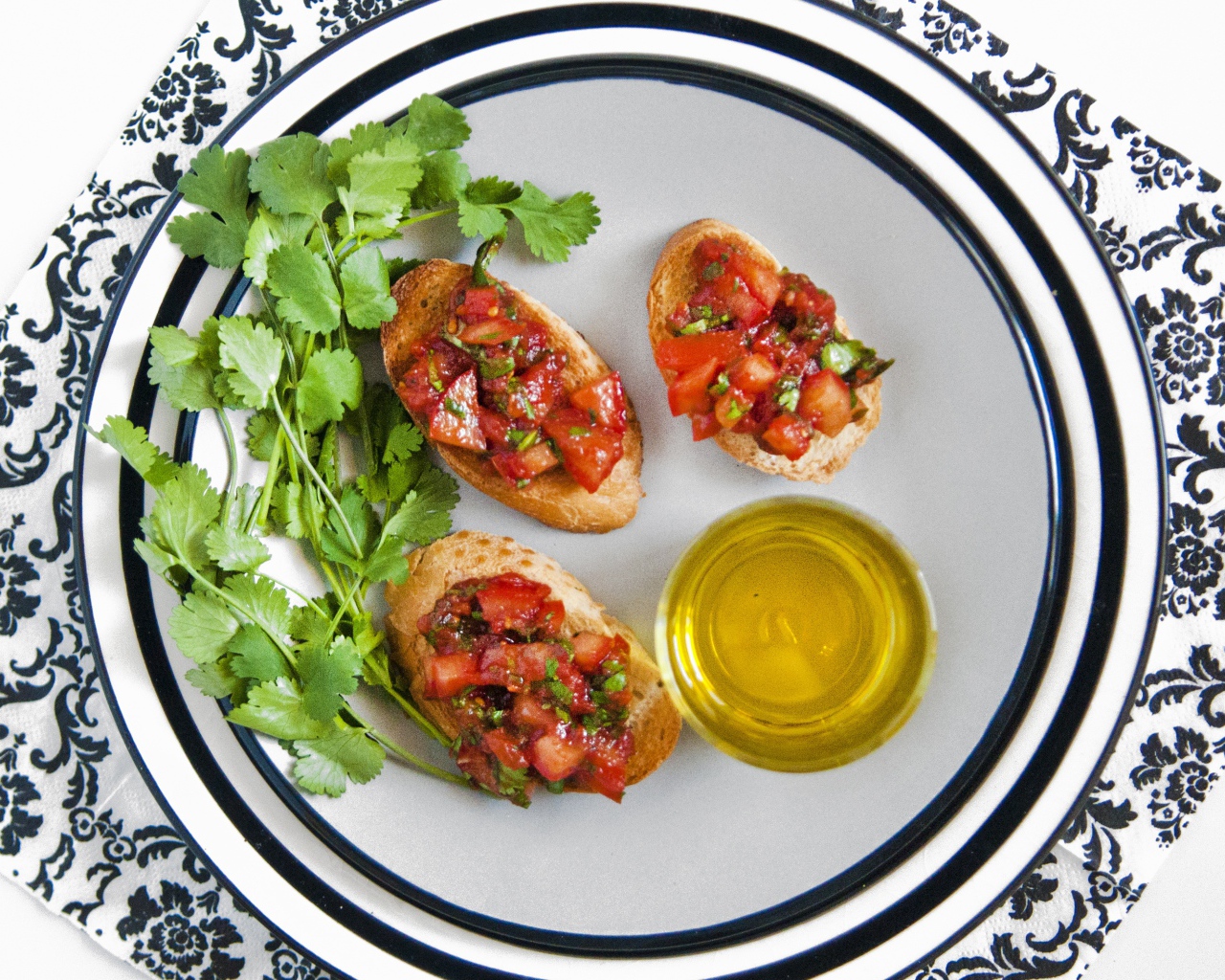 Бутерброды с помидорами на тарелке с петрушкой и маслом