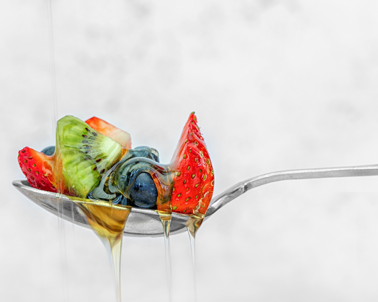 Ягоды в меде на ложке 