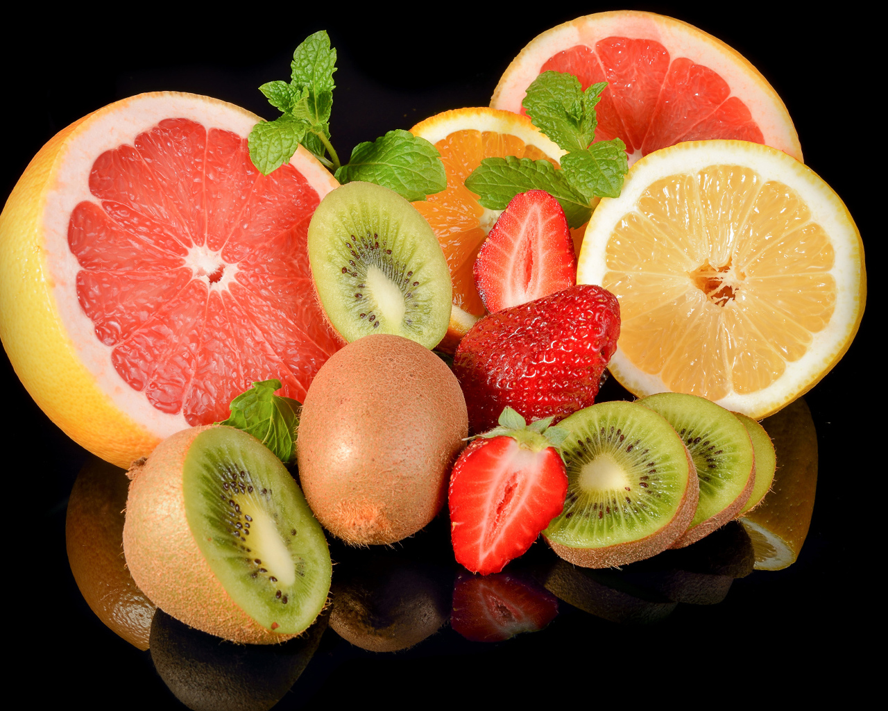 Цитрусовые фрукты с клубникой на черном фоне