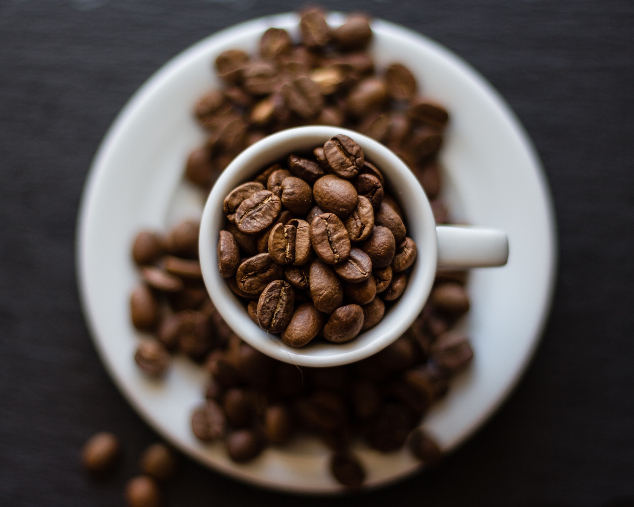 Кофейные зерна в белой чашке на столе 