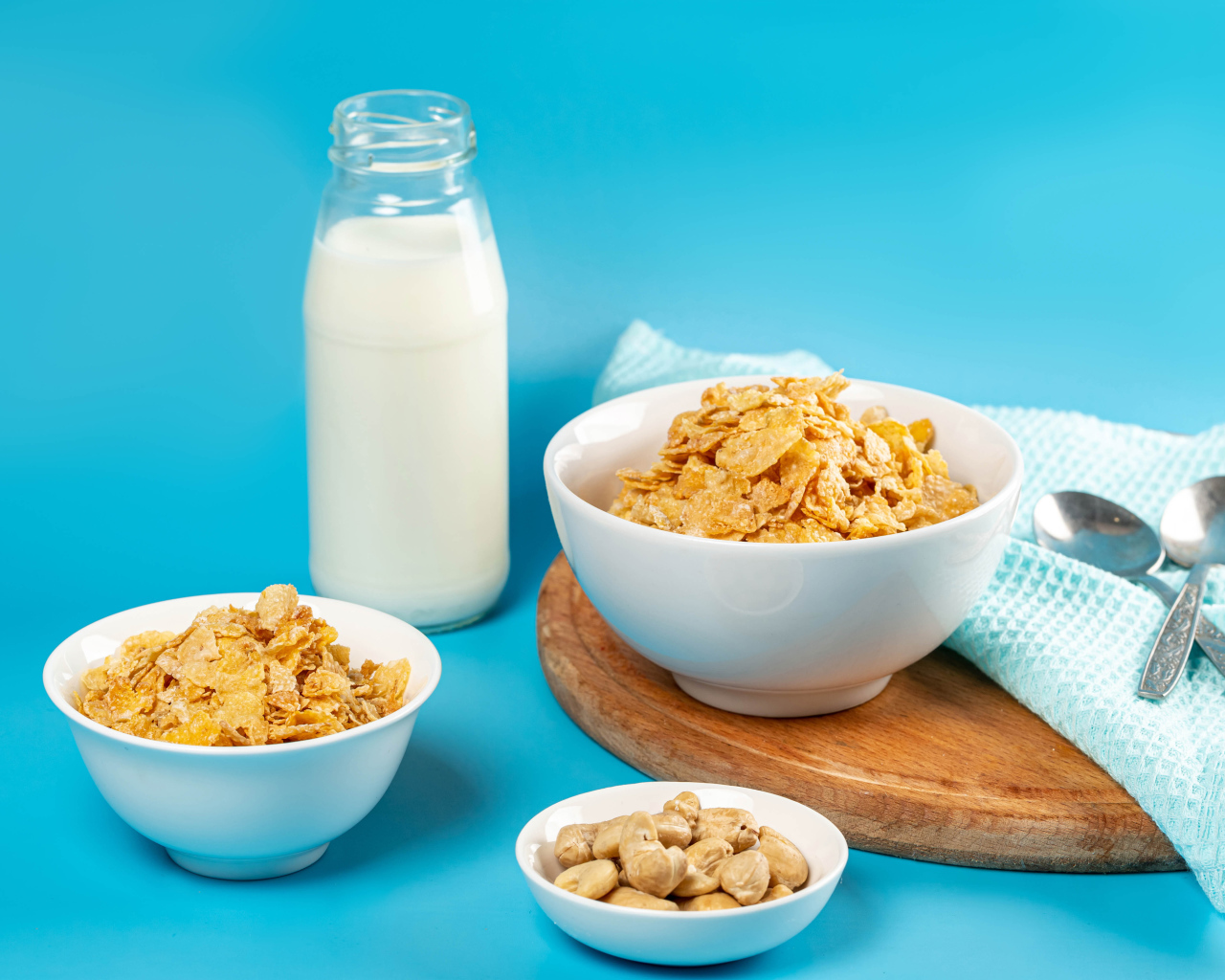 Хлопья на столе с орехами и молоком на голубом фоне