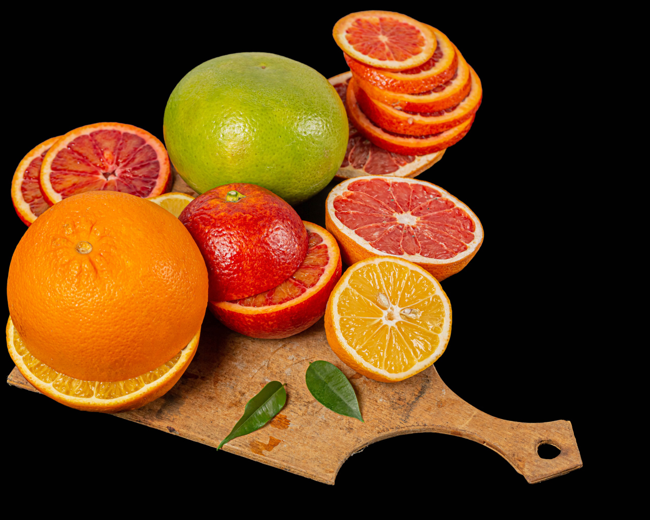 Свежие нарезанные цитрусовые фрукты на черном фоне