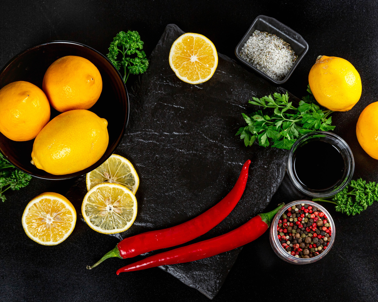 Лимоны на столе с красным перцем, петрушкой  и специями