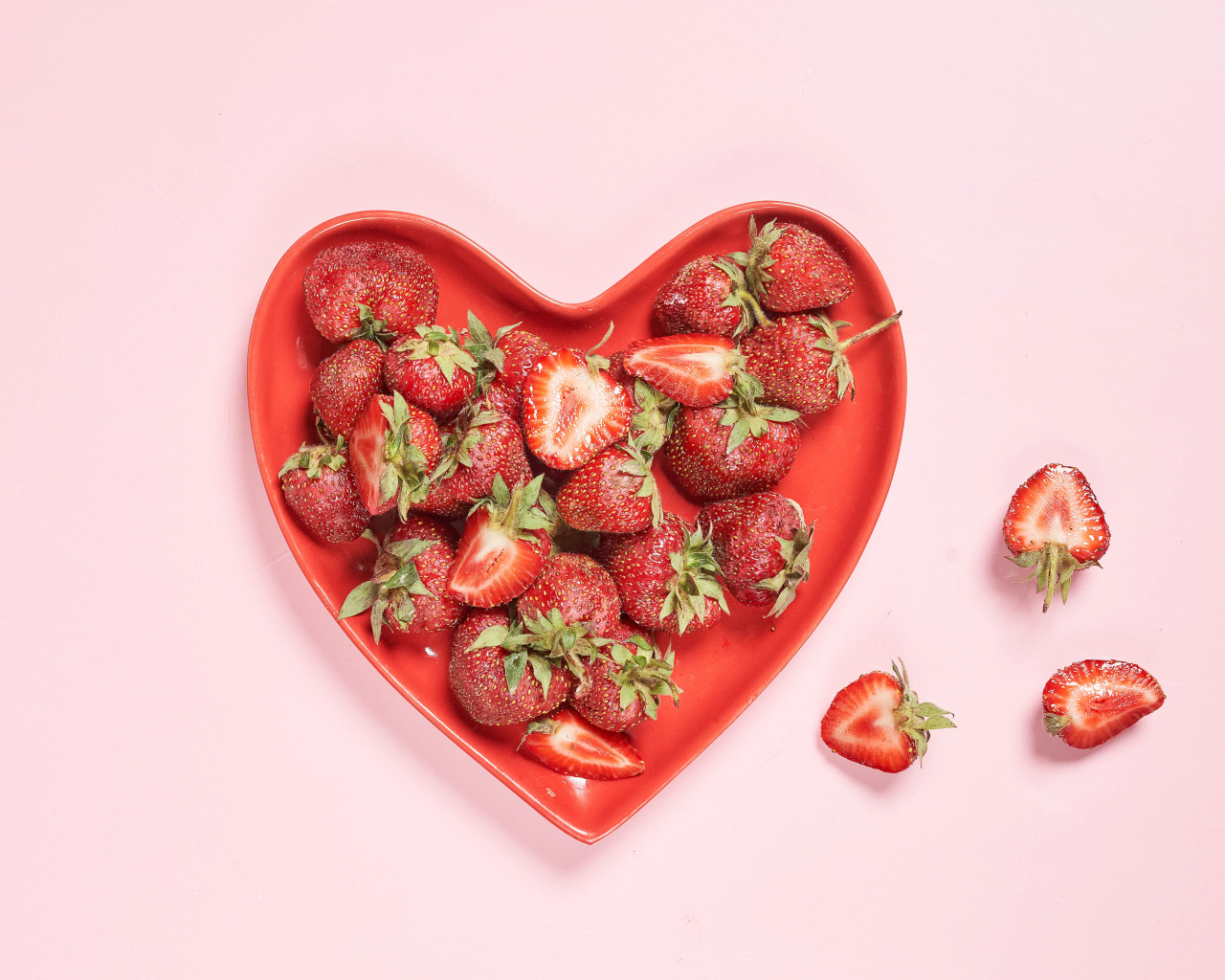 Красная тарелка в форме сердца с клубникой 