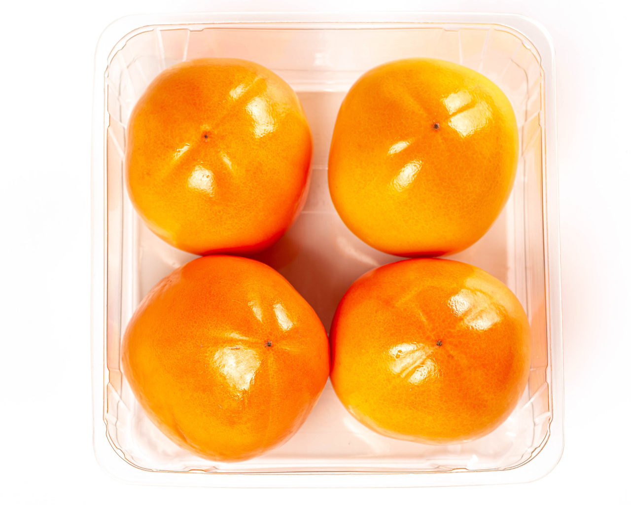 Спелая хурма с лотке на белом фоне