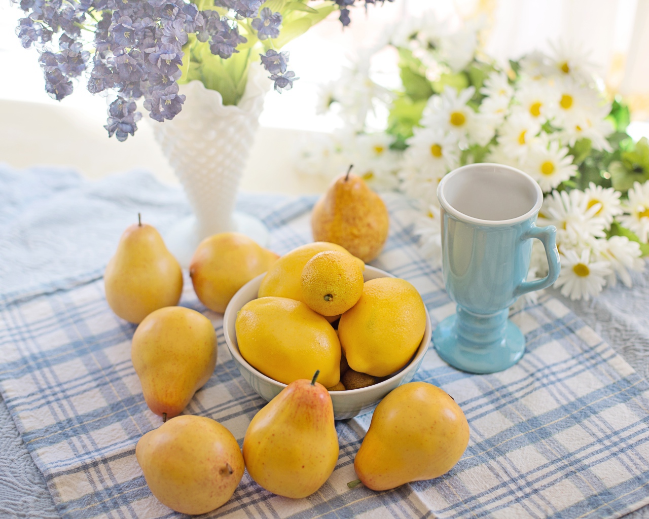 Спелые желтые груши на столе с цветами 