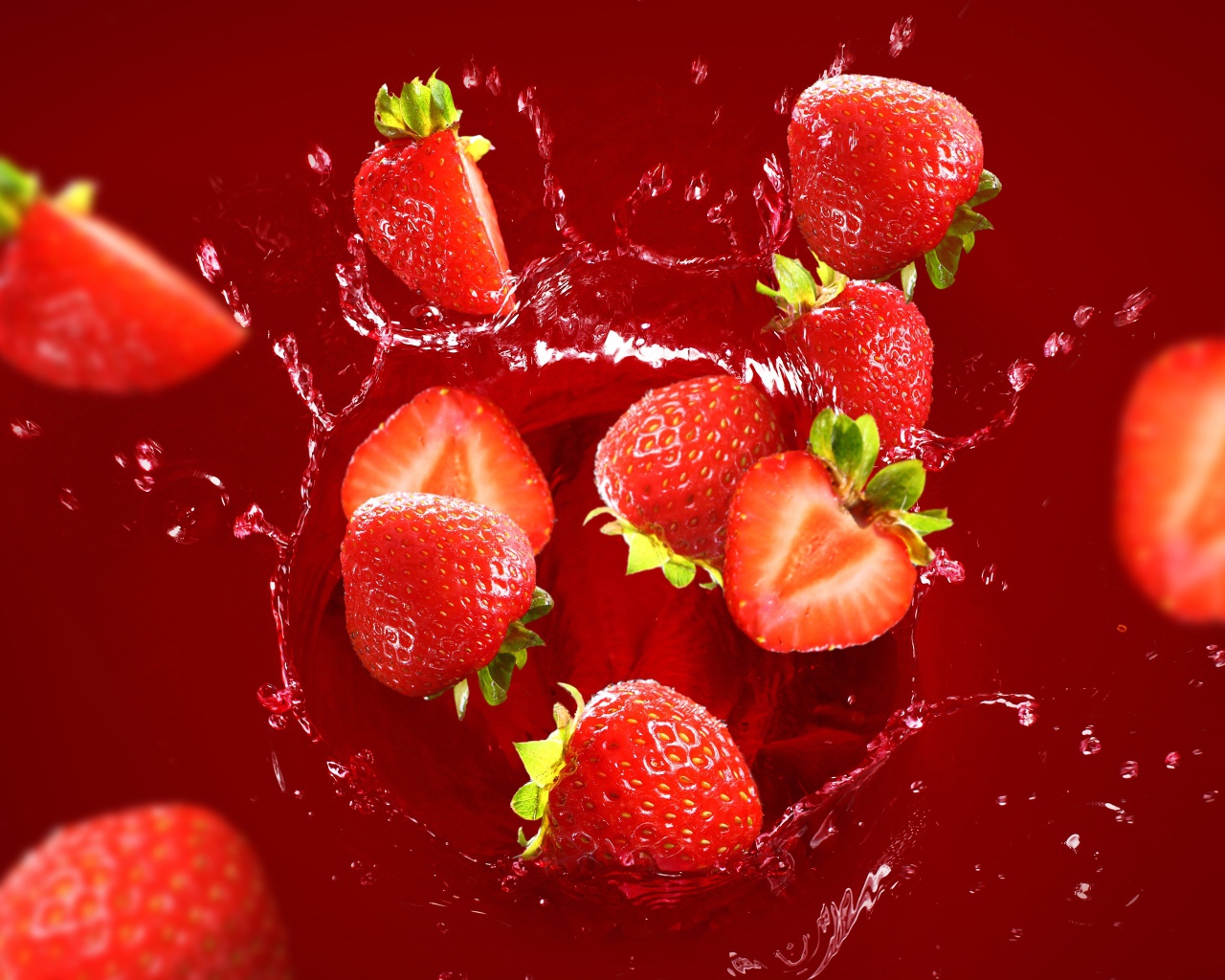 Клубника падает в воду на красном фоне 