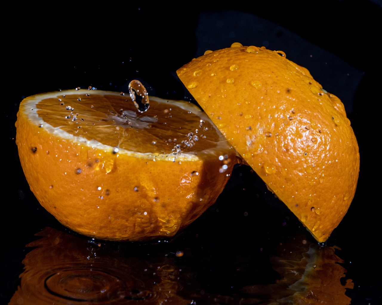 Две половины апельсина на черном фоне 