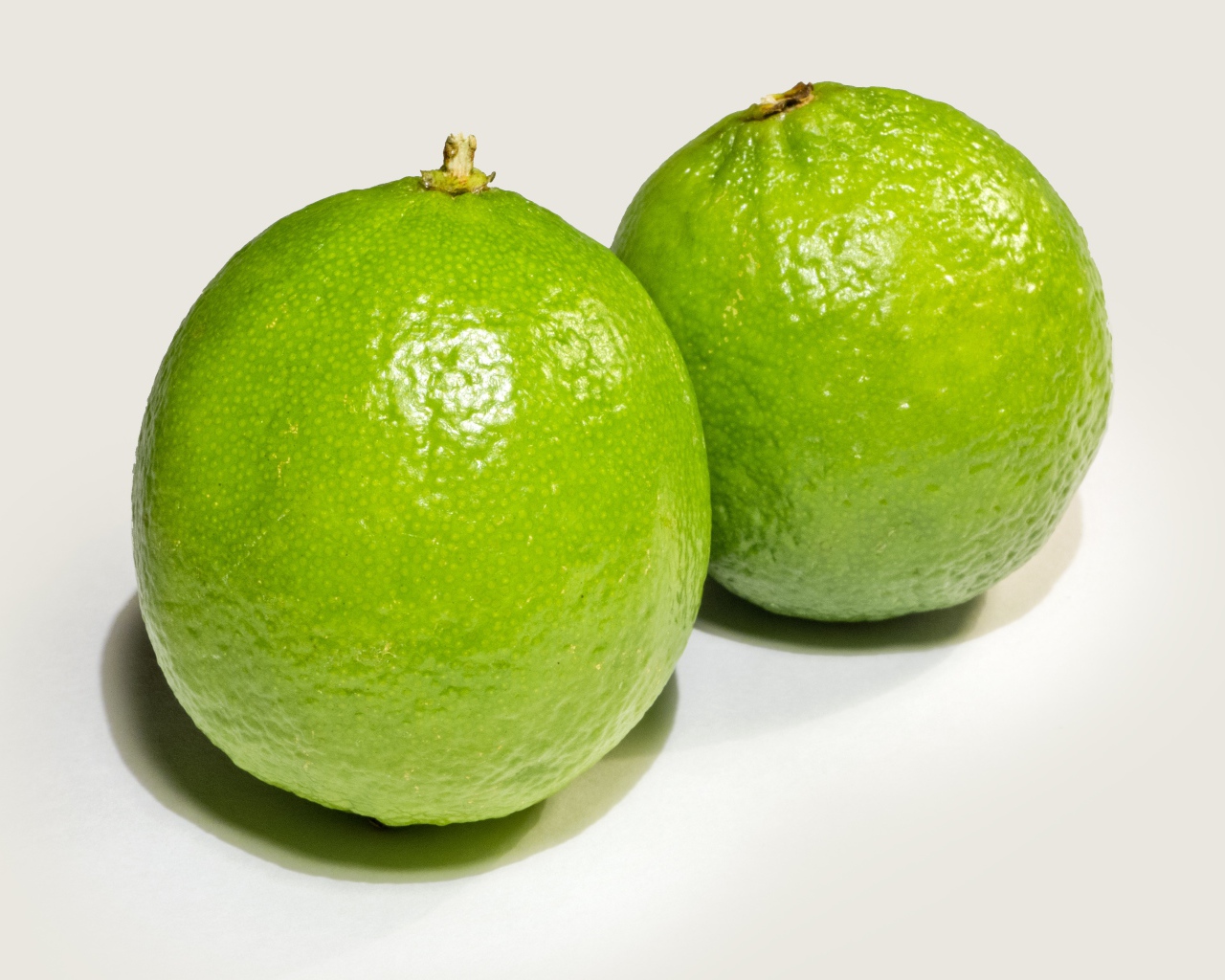 Два больших зеленых лайма на столе