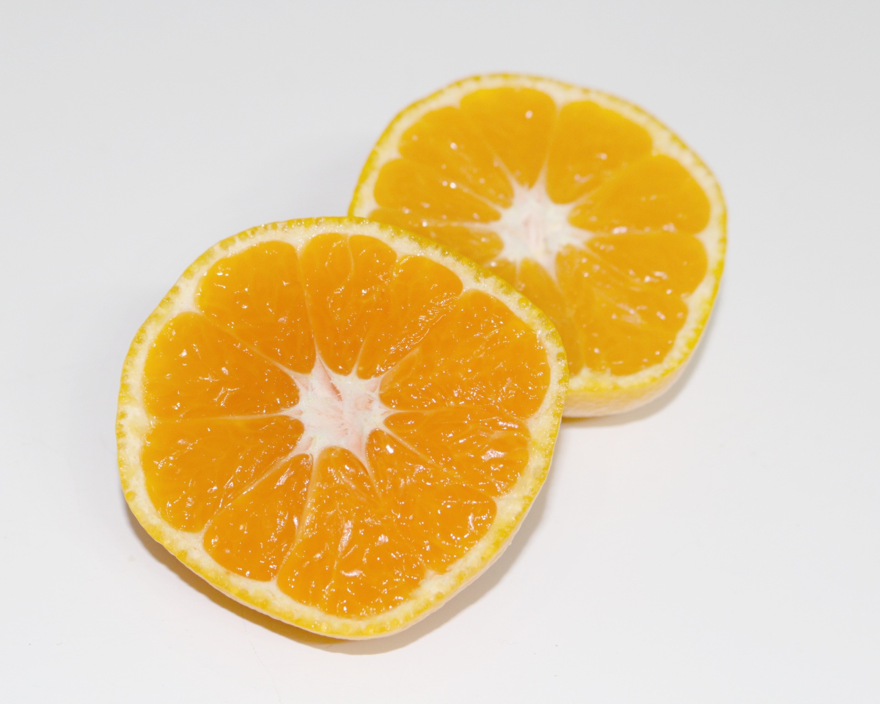 Два кружочка мандарина на сером столе 