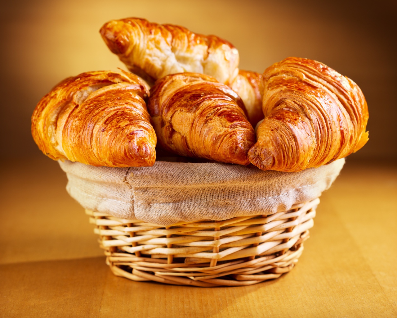 Запеченные румяные круассаны на столе в корзинке 