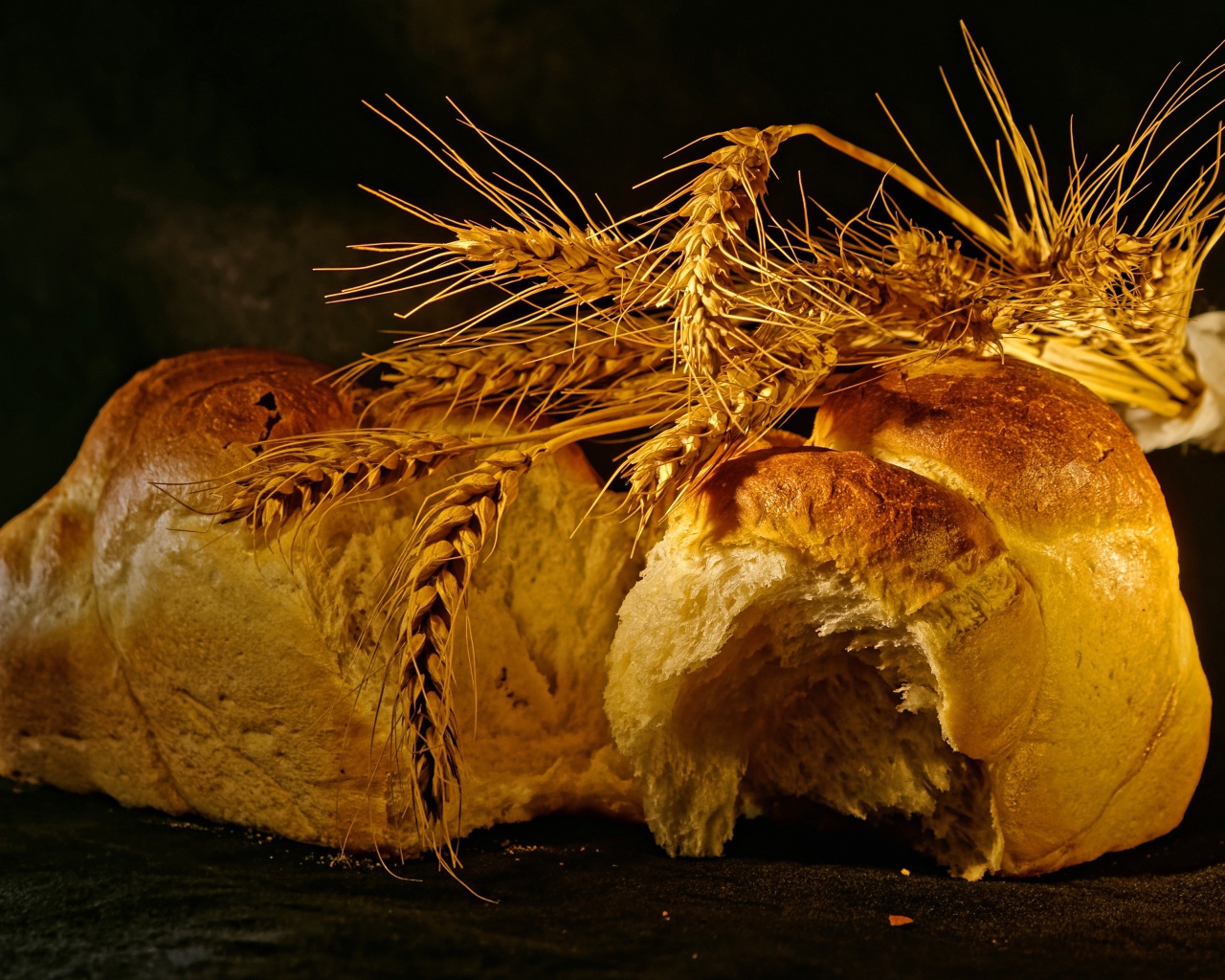 Свежий хлеб с колосьями пшеницы на столе