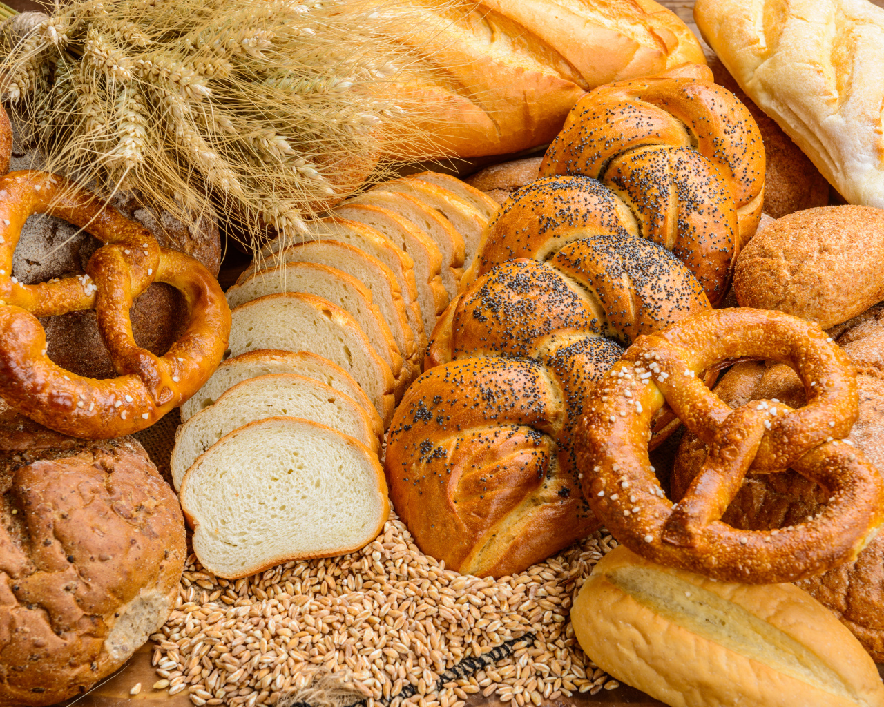 Свежая выпечка на столе с колосьями и зернами пшеницы 