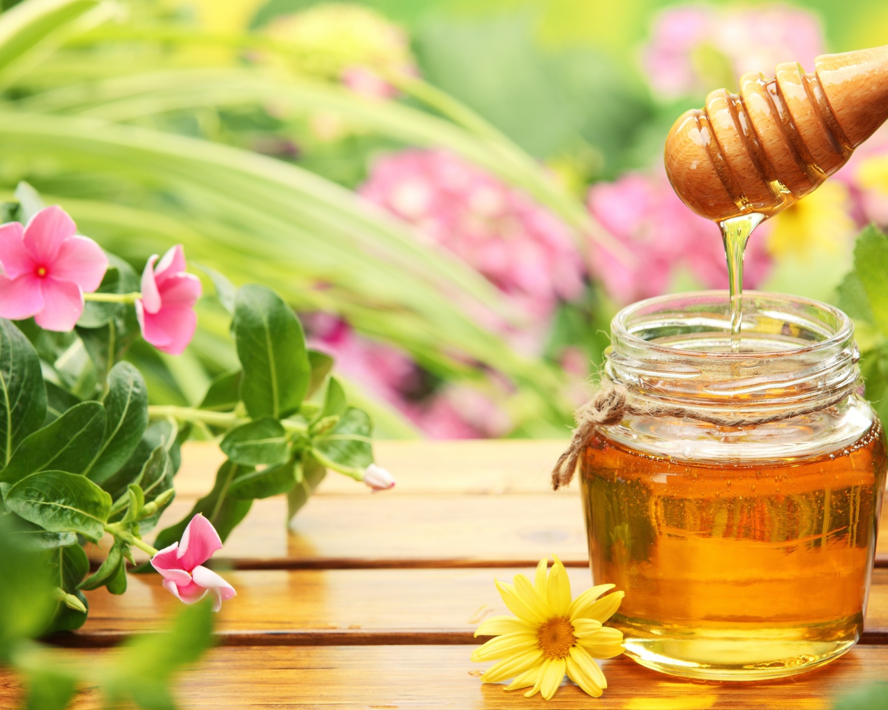 Банка ароматного меда на столе с цветами