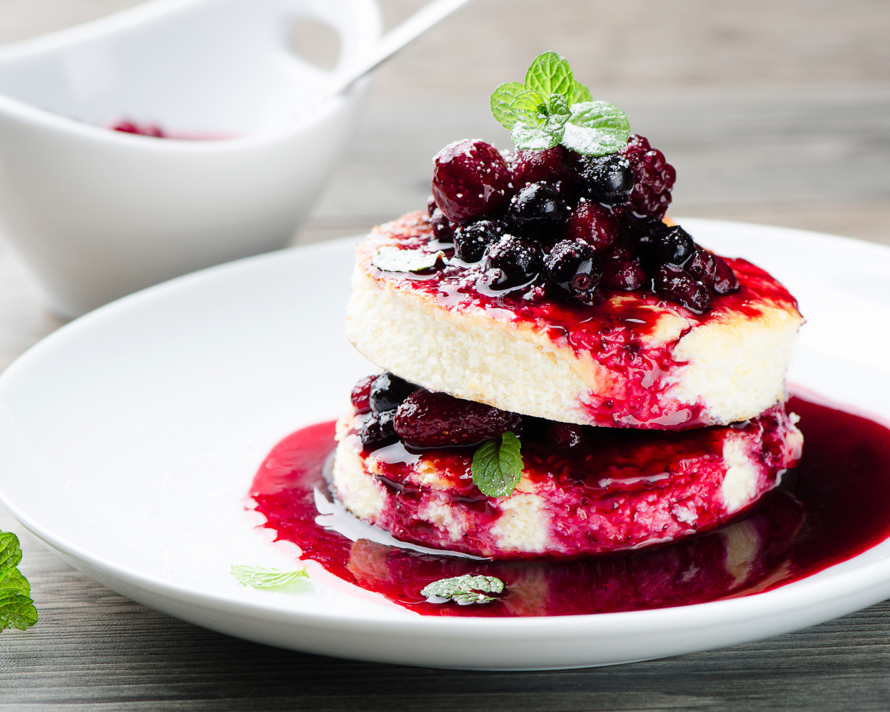 Аппетитные сырники с ягодами на белой тарелке 