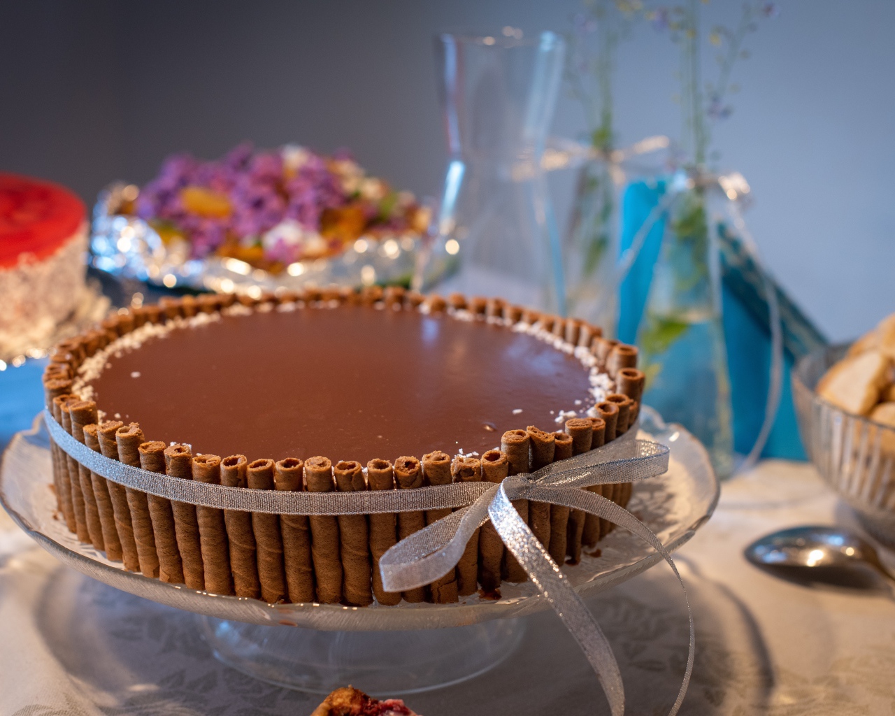 Большой шоколадный торт с трубочками на столе