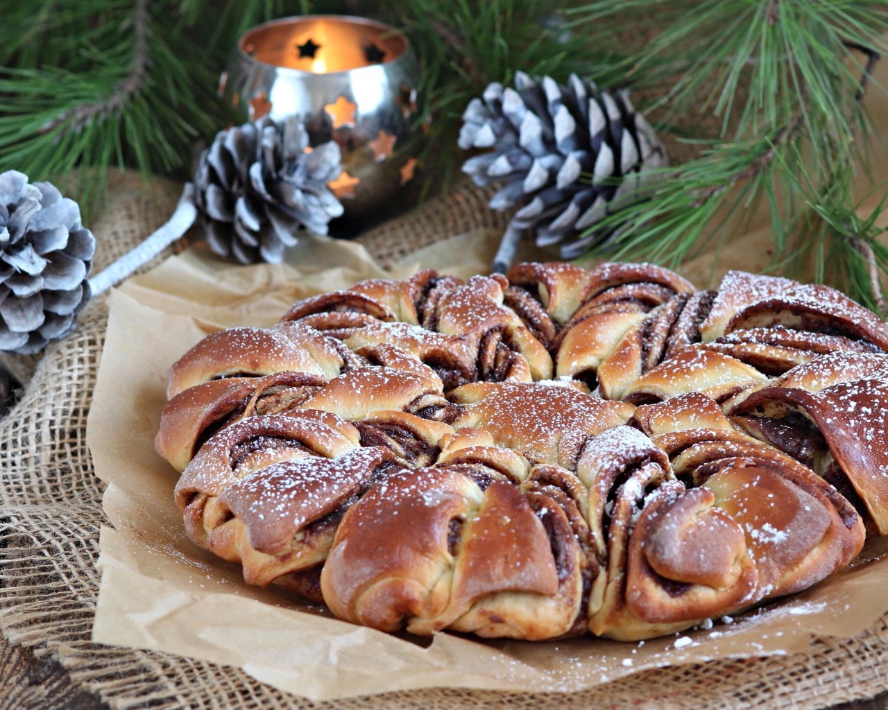 Сдобный венок с вареньем на столе с шишками