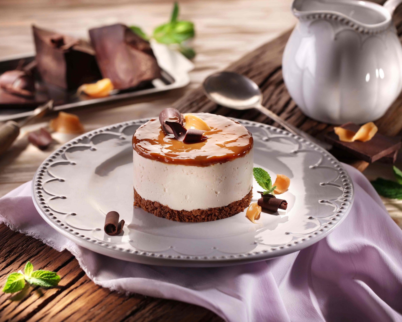 Пирожное на большой круглой тарелке на столе с шоколадом