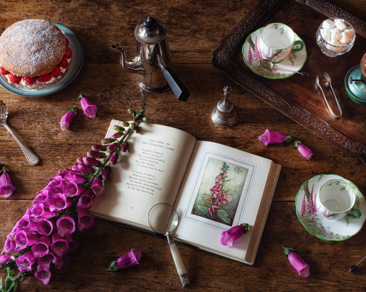 Пирожное на столе с чаем, книгой и цветами 