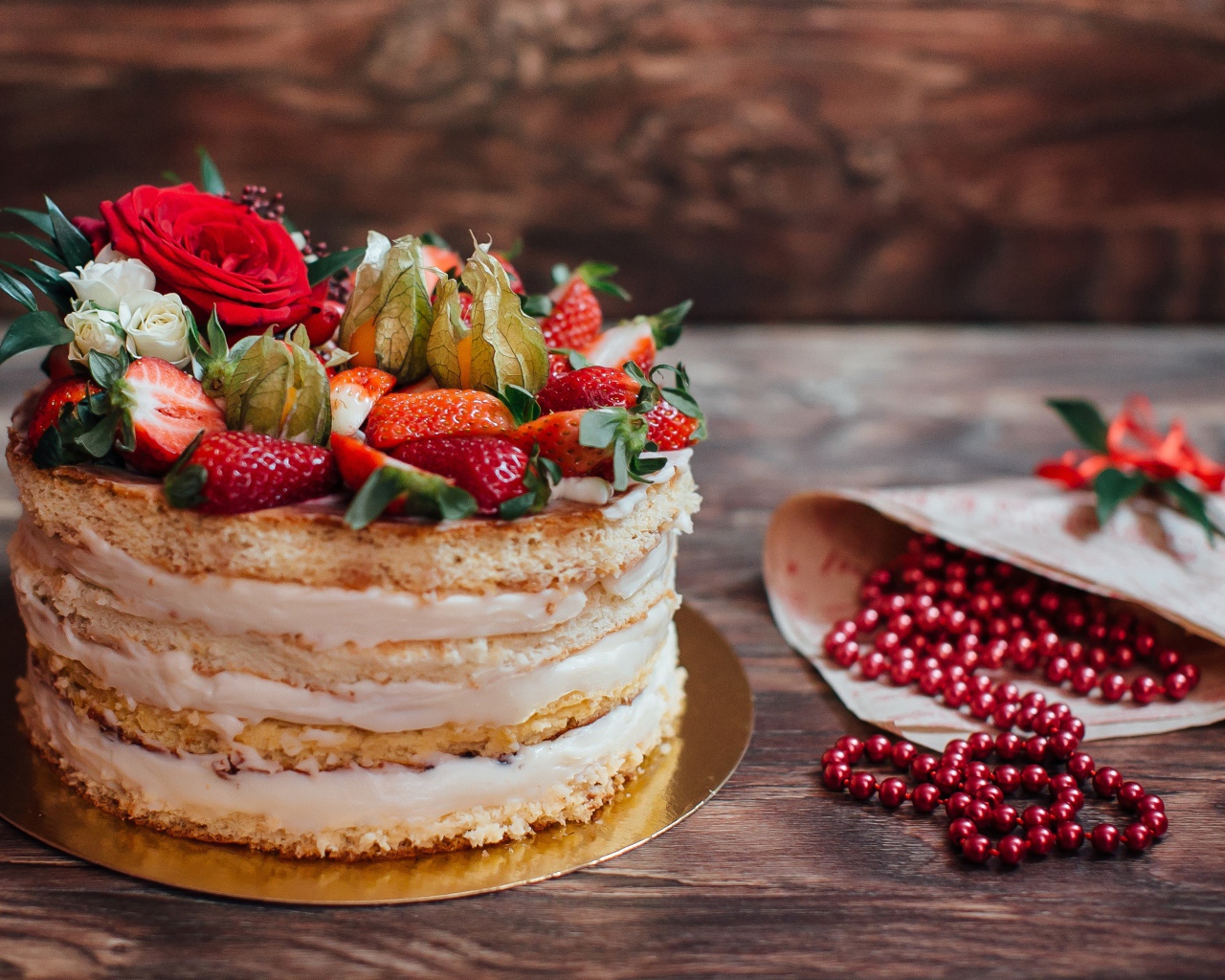 Торт с коржами и ягодным кремом украшен клубникой 