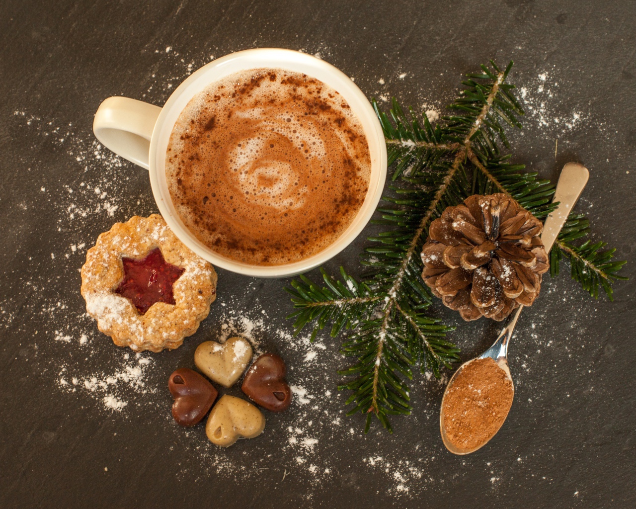 Печенье, конфеты, чашка кофе и еловая ветка на столе 