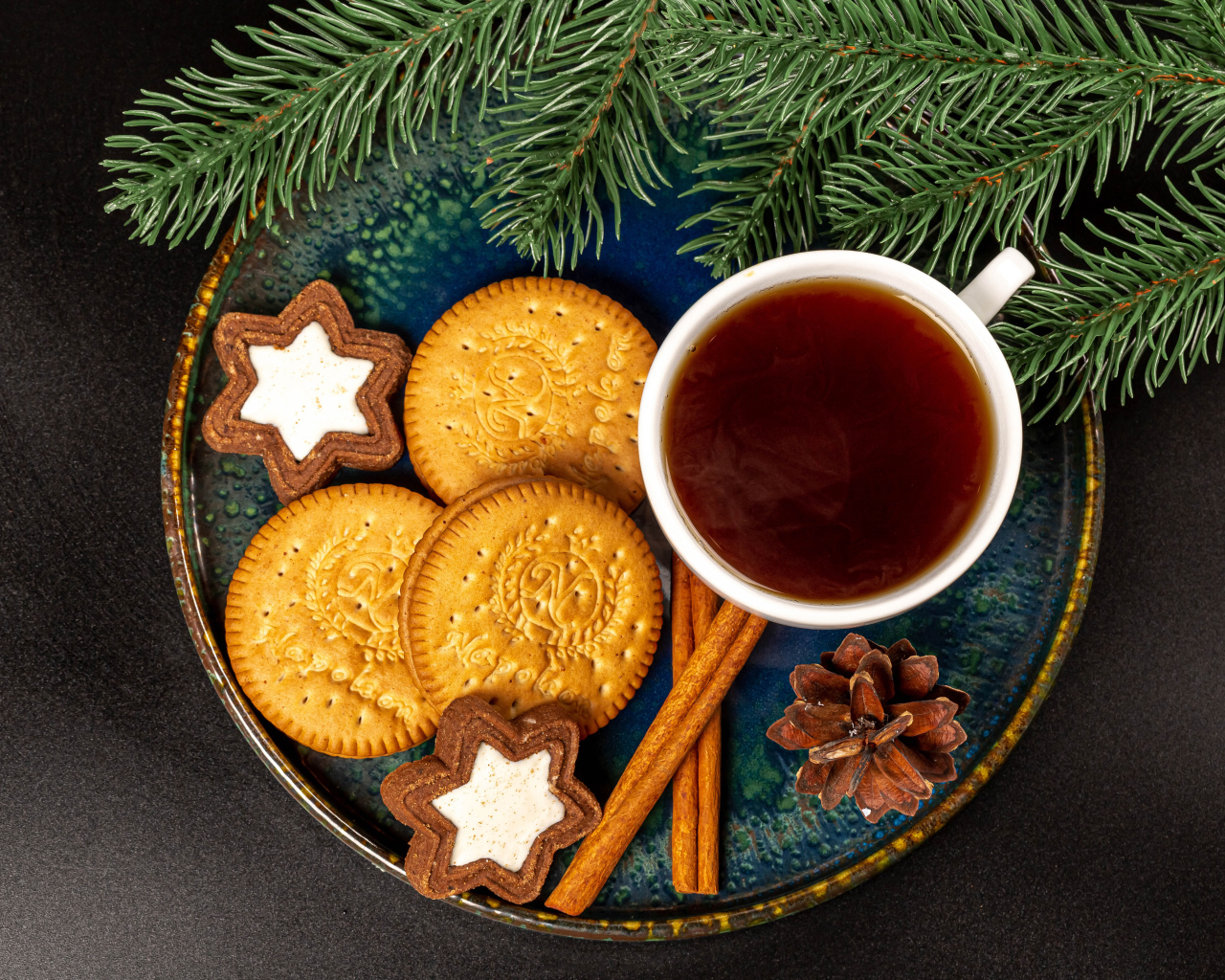 Печенье, чай и корица на столе с еловой веткой