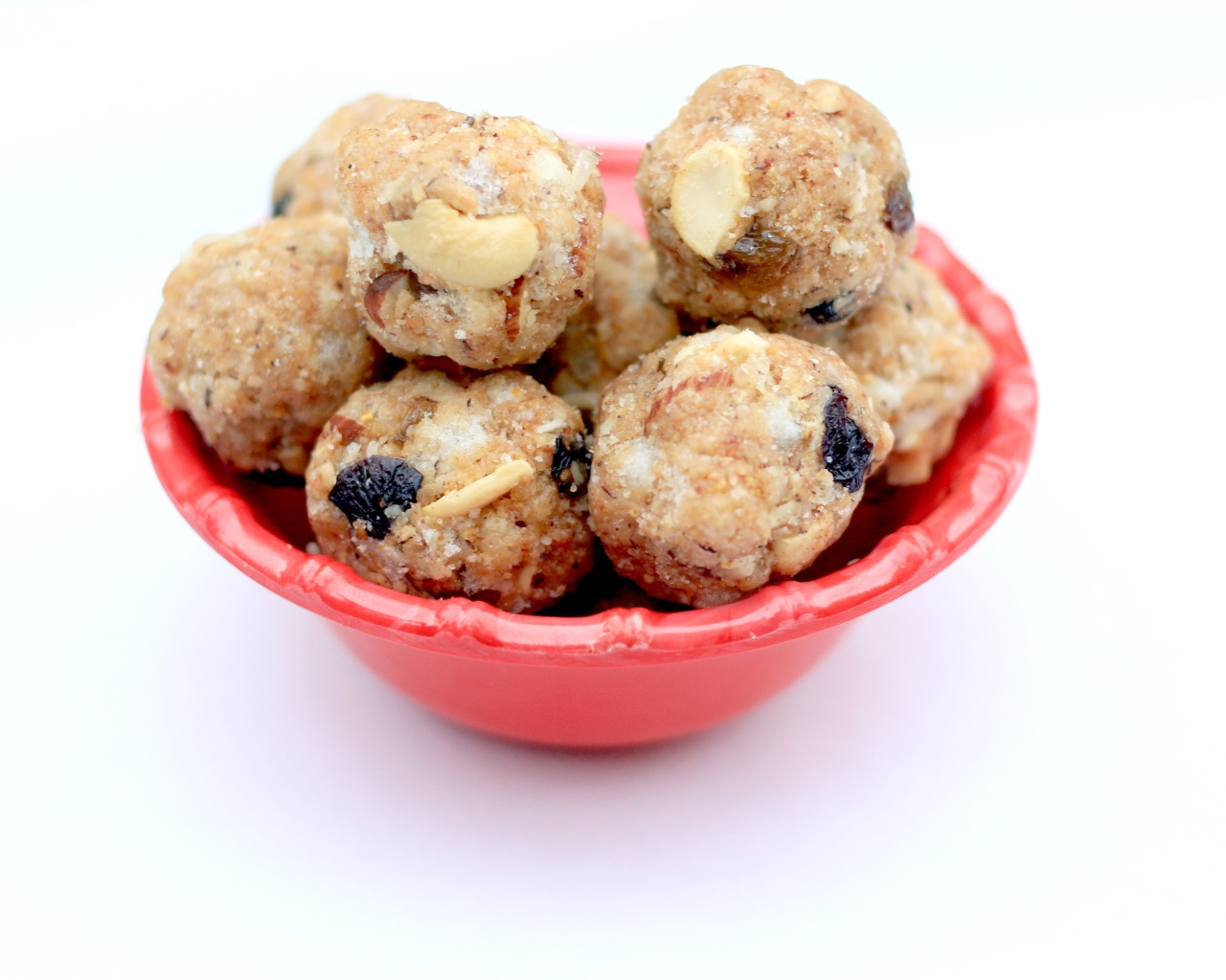 Десерт ладду в красной миске на сером фоне