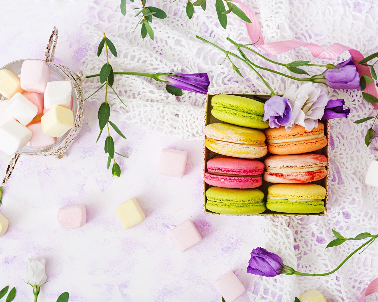 Десерт макарон на столе с кружевной салфеткой и маршмеллоу