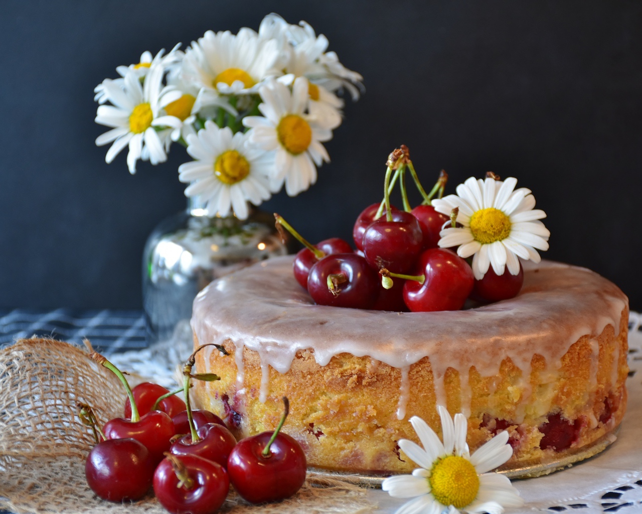 Свежий пирог вишней на столе с ромашками 