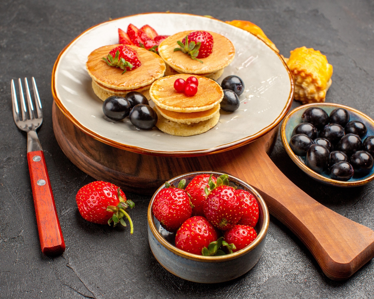 Оладьи с виноградом и клубникой на тарелке 