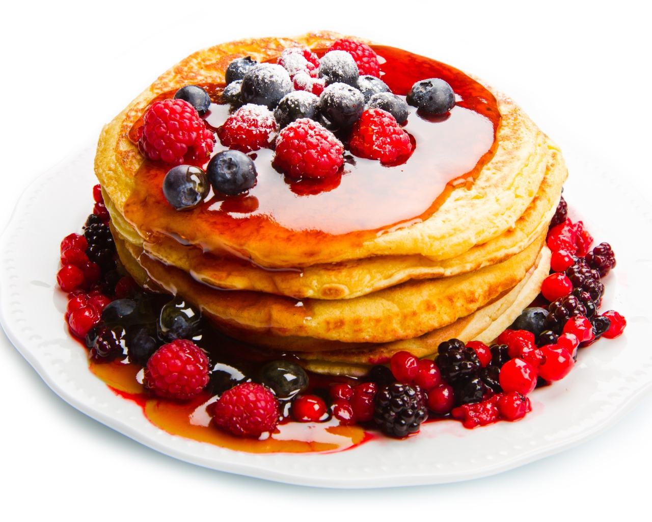 Оладьи с медом и ягодами малины и черники на белом фоне