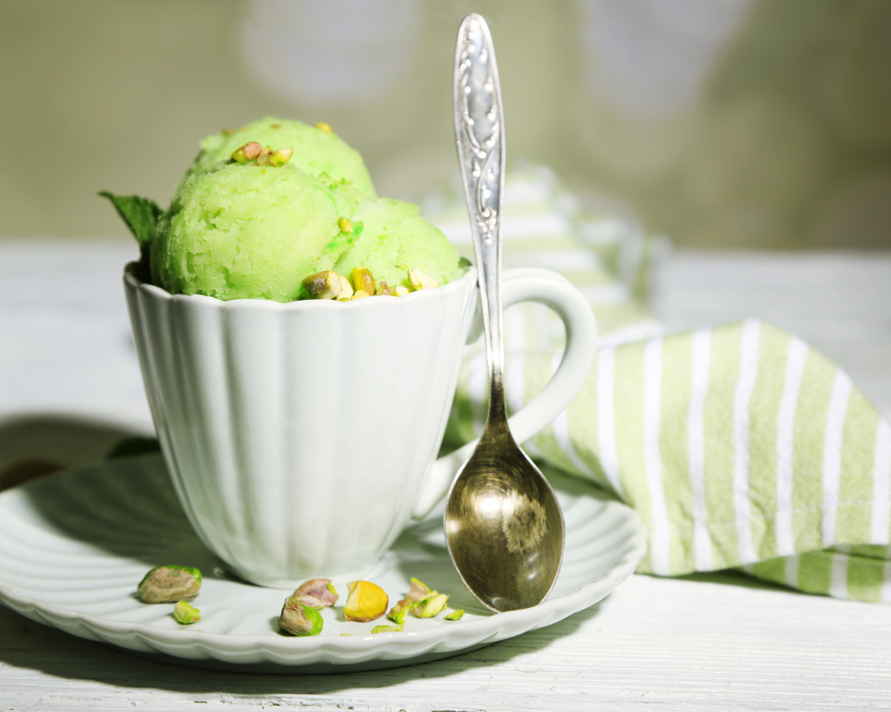 Шарики мороженого в чашке с фисташками