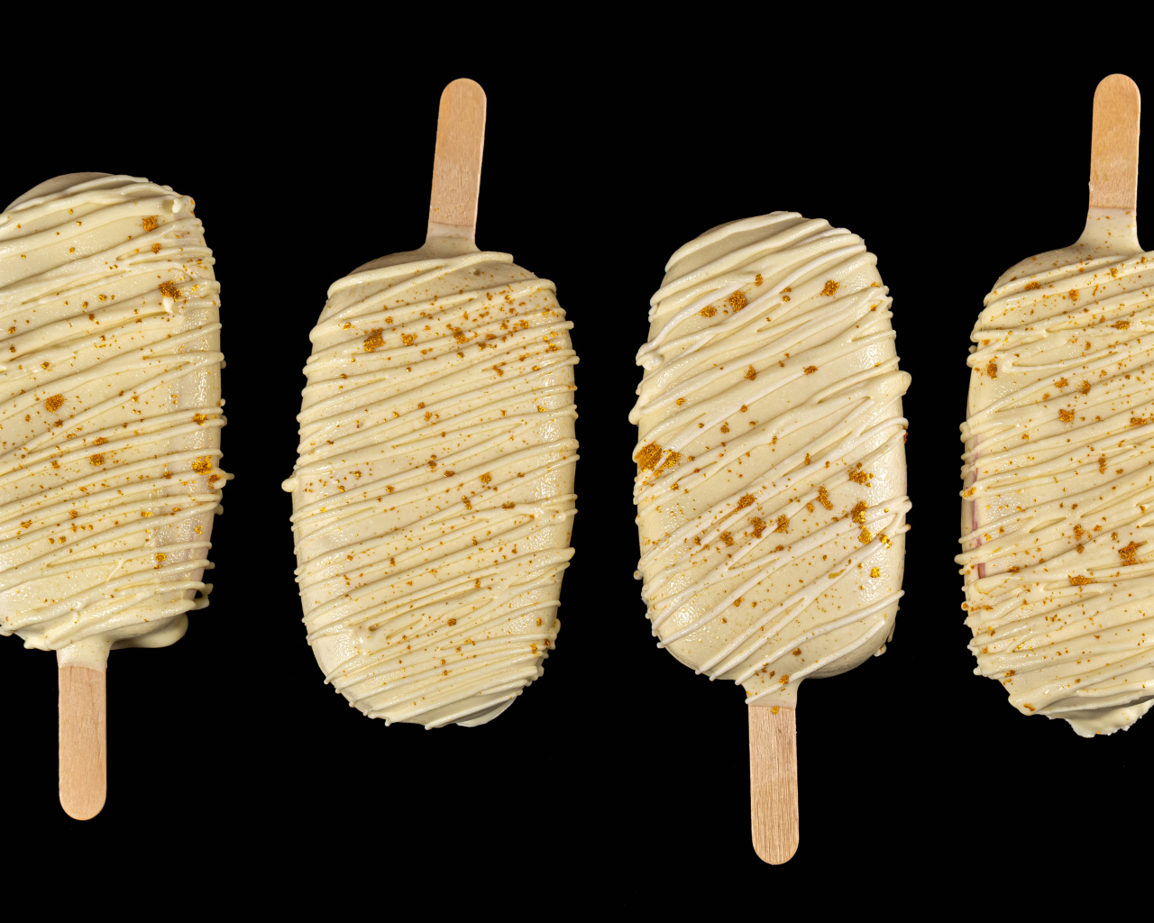 Мороженое на палочке в белом шоколаде на черном фоне