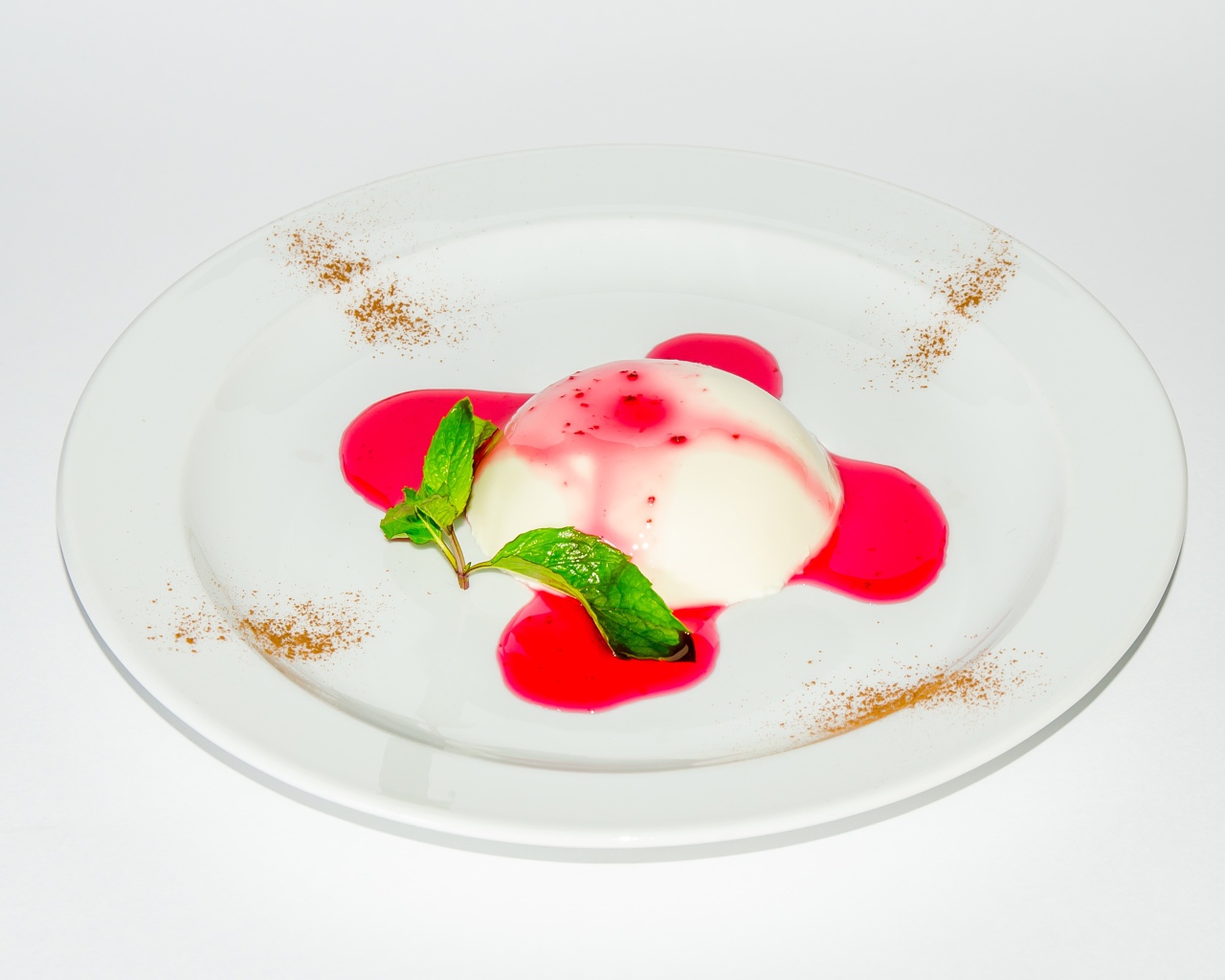 Молочное желе с джемом на белой тарелке 