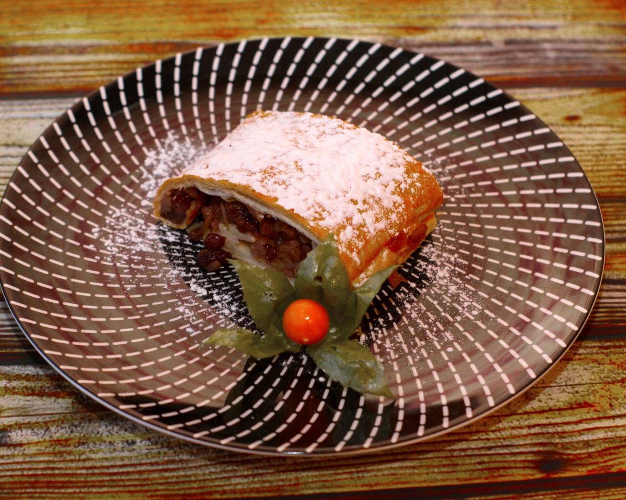 Кусок яблочного штруделя на тарелке 